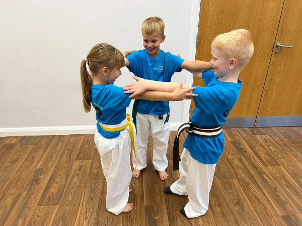 Three children stood in a circle with arms locked